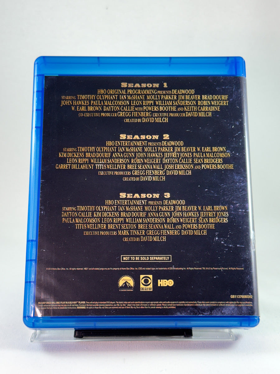 Bakside av Blu-ray-cover til Deadwood – The Ultimate Collection, oversikt over sesong 1–3 i HBOs prisvinnende westernserie, brukt Blu-ray hos Brukbar Film