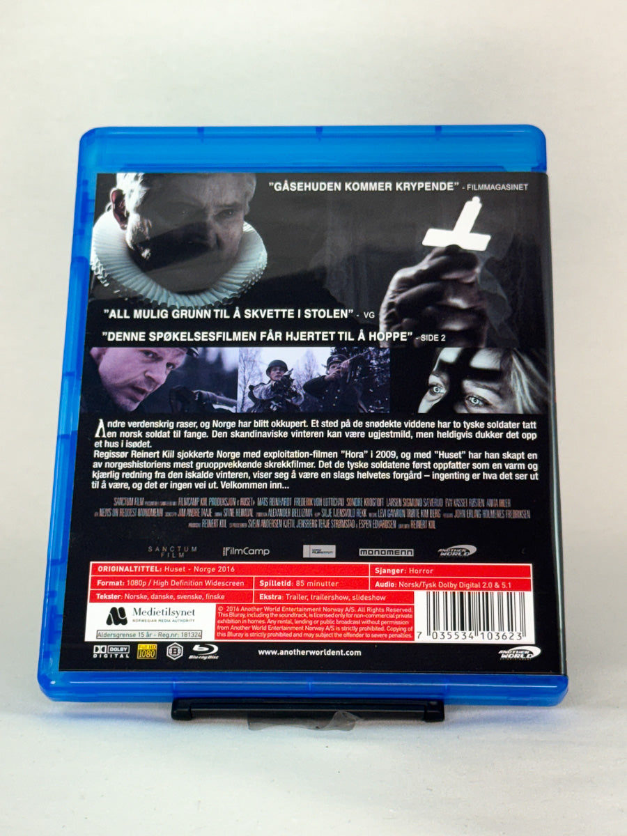 Bakside av Blu-ray-cover for Huset – norsk skrekkfilm med mørk atmosfære og omtaler, brukt film hos Brukbar Film.
