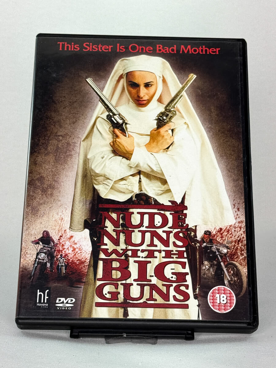 Forside av DVD-cover til Nude Nuns with Big Guns – grindhouse-action om hevn og korrupsjon, brukt DVD hos Brukbar Film.