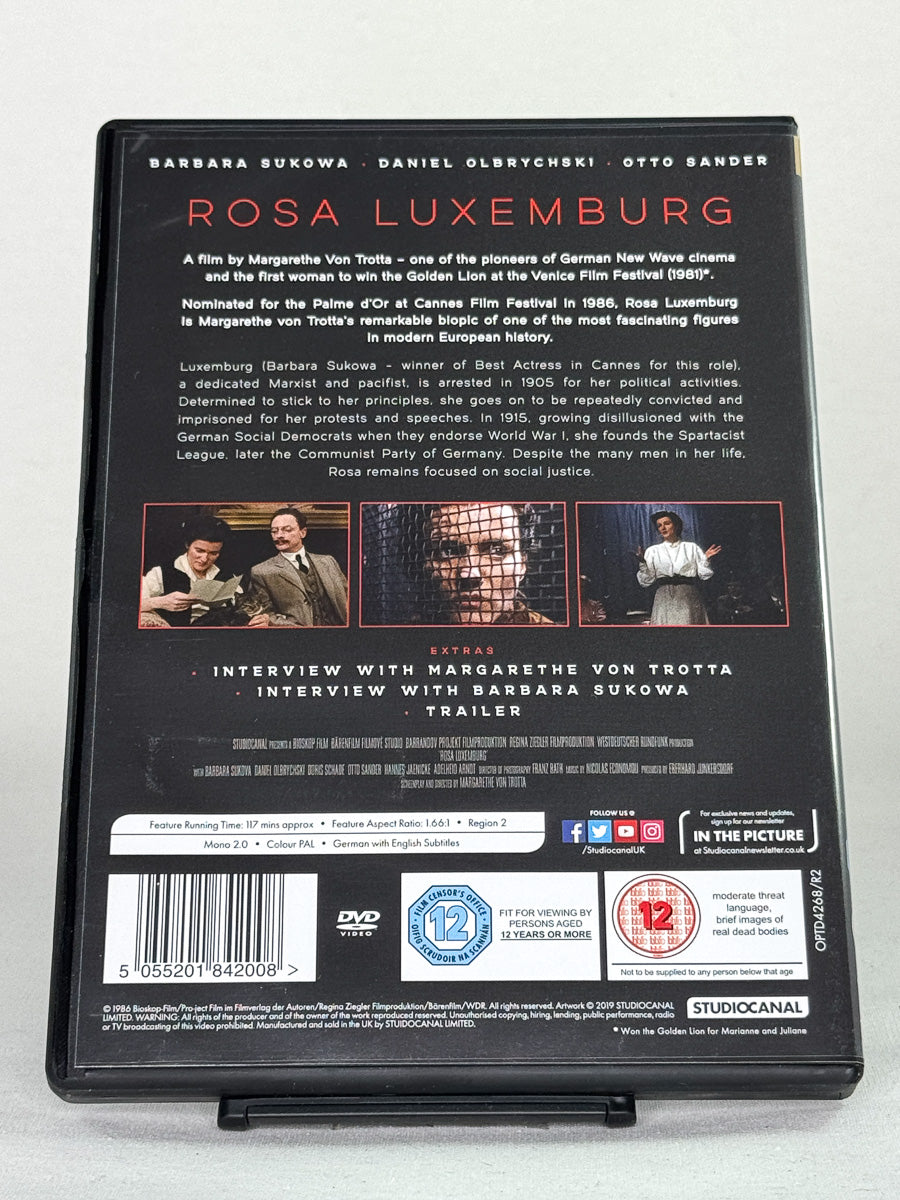 Bakside av DVD-cover til Rosa Luxemburg med informasjon om filmens utgaver og bonusmateriale; brukt DVD hos Brukbar Film.