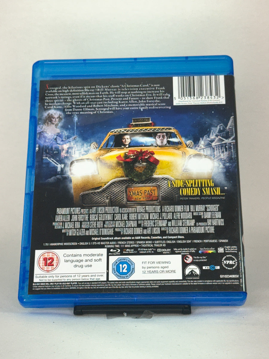 Bakside av Blu-ray-cover til Scrooged – sarkastisk og varm julefilm fra 80-tallet, original brukt Blu-ray hos Brukbar Film.