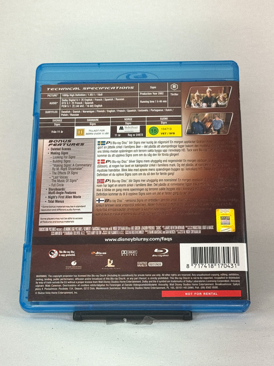 Bakside av Blu-ray-cover for Signs – filmomtale, lydformater og teknisk info, brukt Blu-ray hos Brukbar Film.