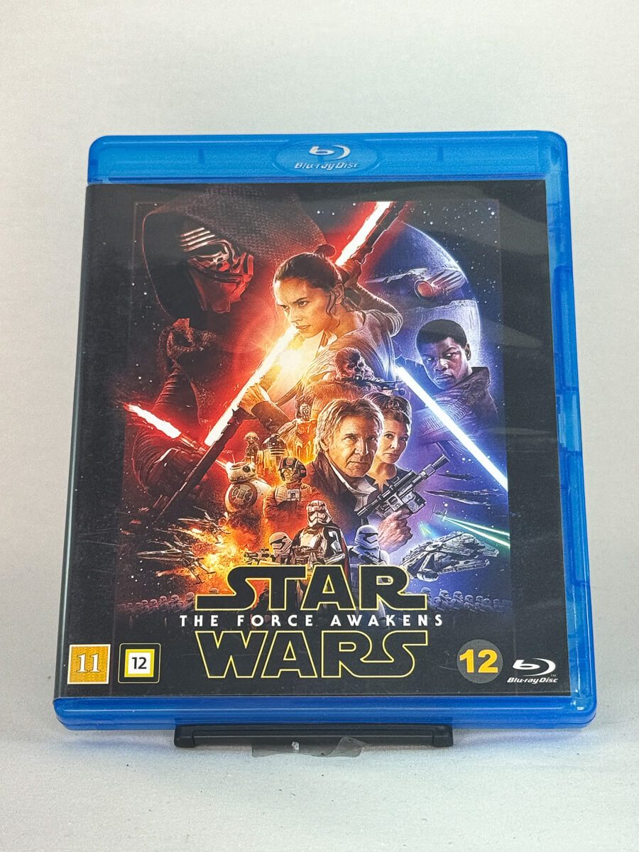 Forside av Blu-ray-cover til Star Wars: The Force Awakens – eventyrlig fortsettelse av sagaen med Daisy Ridley, John Boyega og Harrison Ford, brukt film hos Brukbar Film.