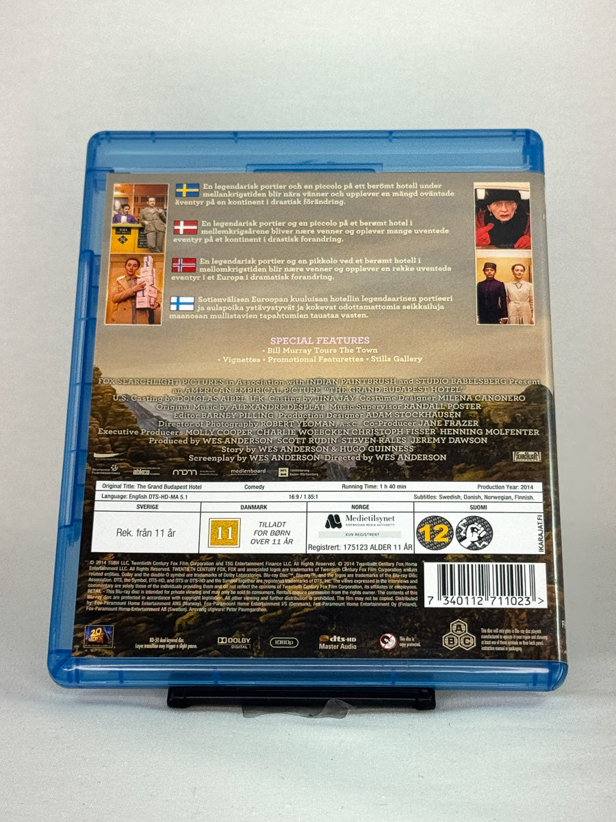 Bakside av Blu-ray-cover for The Grand Budapest Hotel – detaljert utgave med omtaler, bonusmateriale og rolleoversikt, brukt film hos Brukbar Film.