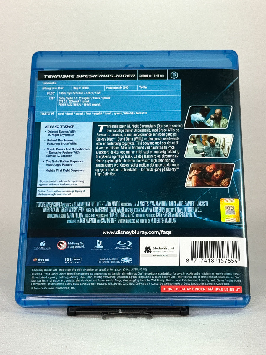 Bakside av Blu-ray-cover for Unbreakable – filmomtale, teknisk info og bonusinnhold, brukt Blu-ray hos Brukbar Film.