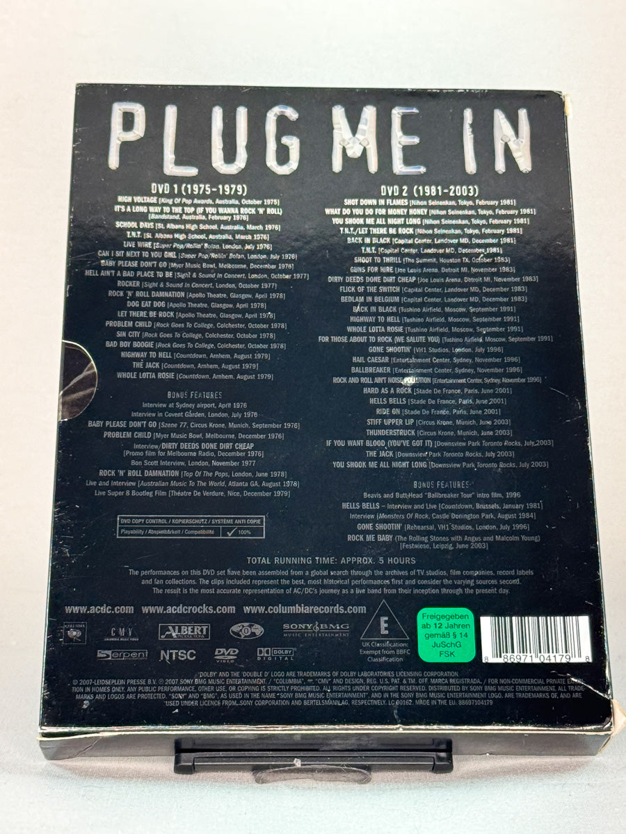 Bakside av DVD-cover til AC/DC – Plug Me In – inneholder timer med konsertopptak, backstage-klipp og historiske høydepunkter fra AC/DCs turneer, brukt originalutgave på DVD hos Brukbar Film.