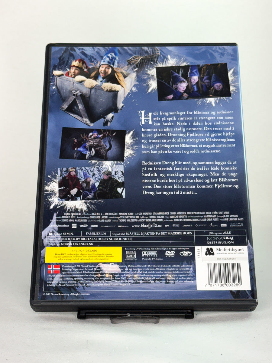 Bakside av DVD-cover til Blåfjell 2 – Jakten på det magiske horn – forteller om filmen og dens magiske univers for hele familien – brukt DVD tilgjengelig hos Brukbar Film.
