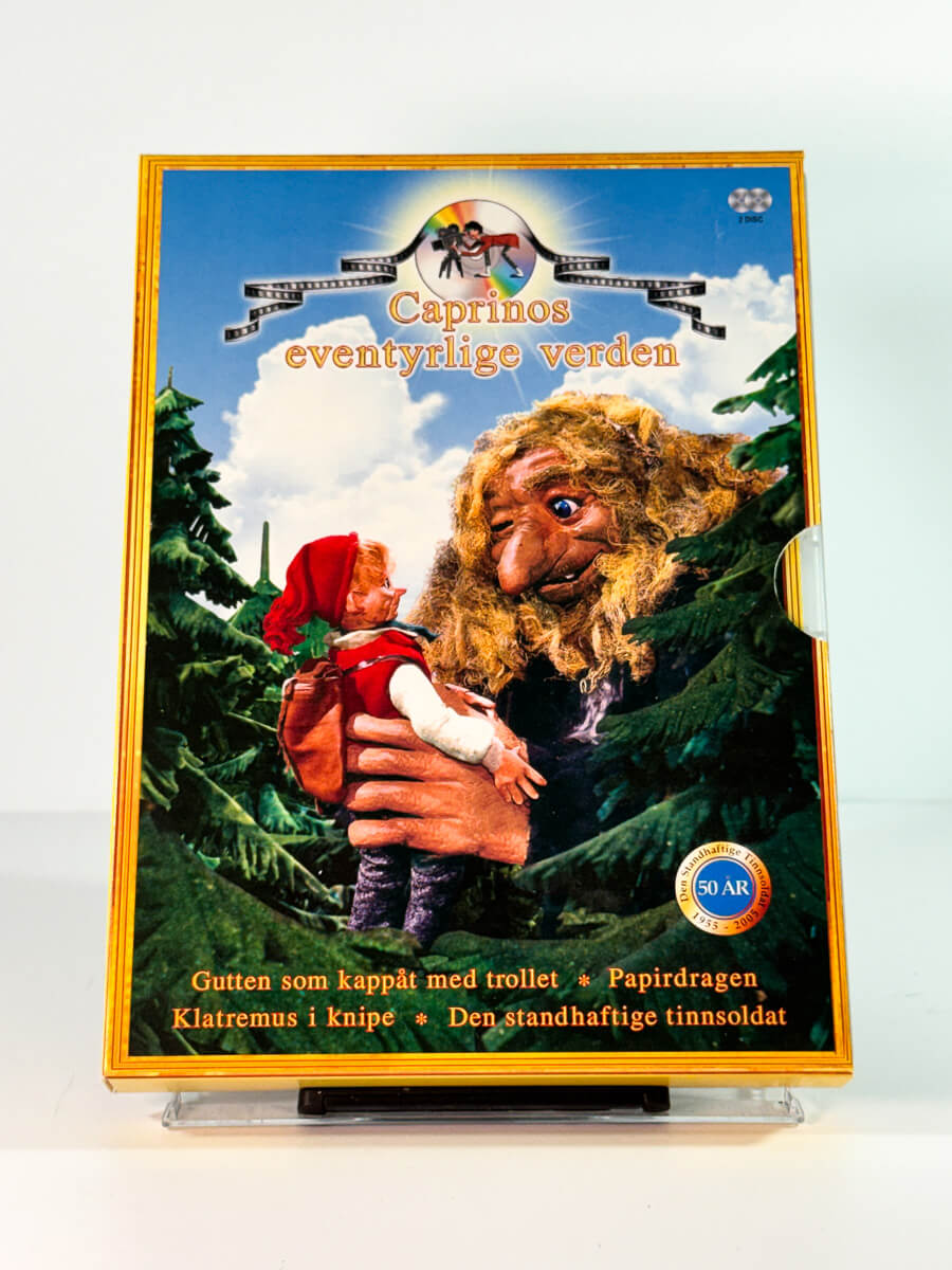 Forside av slipcase cover til caprinos eventyrlige verden – gutten som kappåt med trollet papirdragen klatremus i knipe den standhaftige tinnsoldat, bruktfilm på DVD hos Brukbar Film