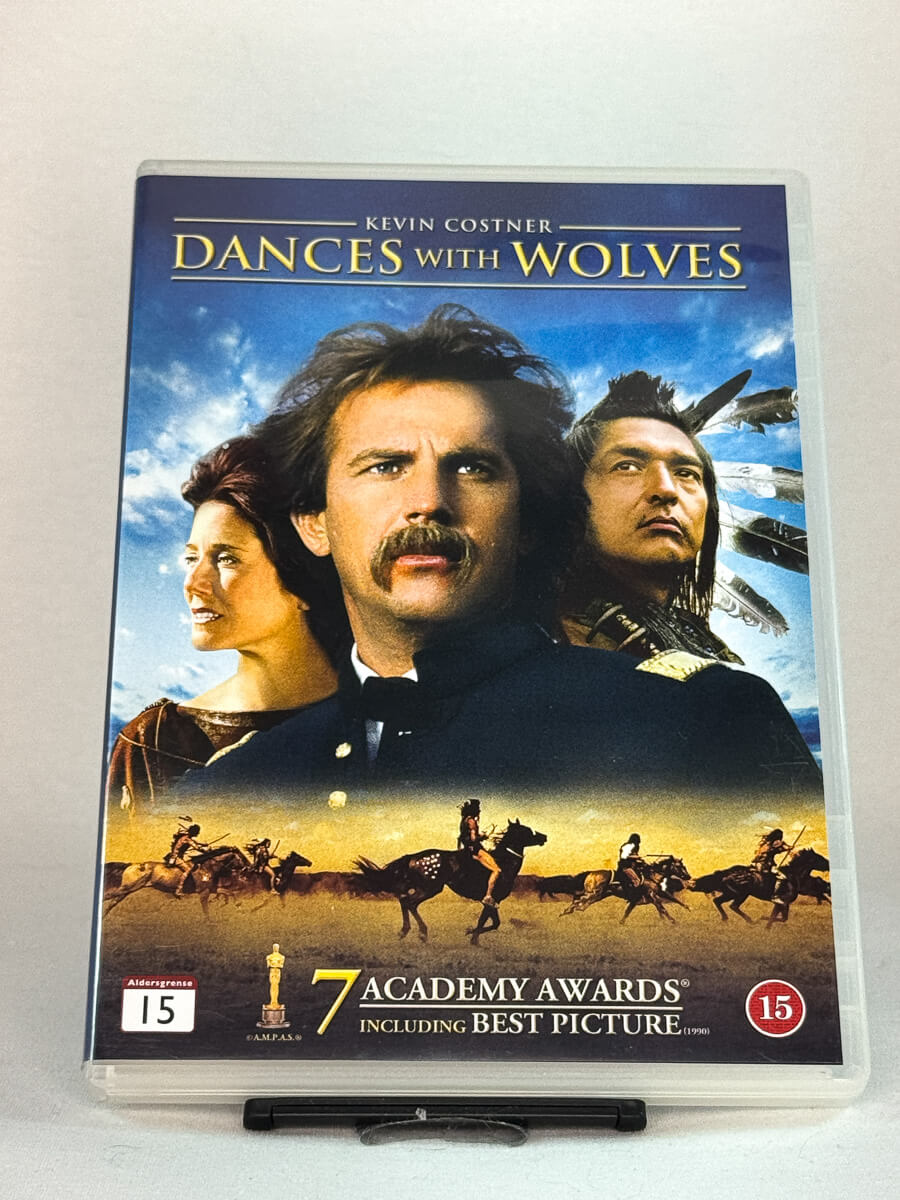 Forside av DVD-cover til Dances with Wolves (1990) – Oscar-vinnende western-epos regissert av og med Kevin Costner – brukt film på DVD hos Brukbar Film.