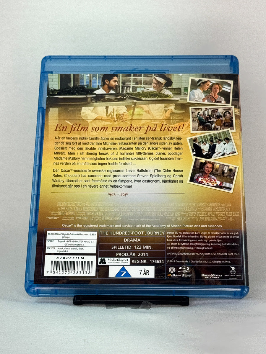 Bakside av Blu-ray-cover for En trettimeters reise (The Hundred-Foot Journey) – brukt mat- og kulturdrama på Blu-ray, tilgjengelig hos Brukbar Film
