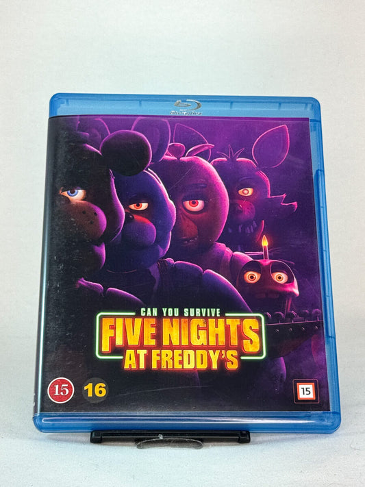 Forside av Blu-ray-cover til Five Nights at Freddy’s – filmatiseringen av den populære skrekkspillserien, produsert av Blumhouse, brukt Blu-ray hos Brukbar Film.