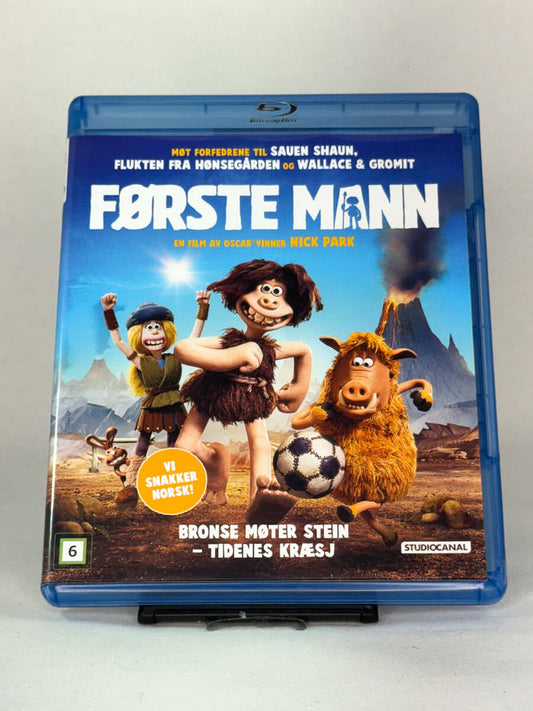 Forside av Blu-ray-cover til Første mann – stop motion-komedie fra skaperne av Wallace & Gromit, med norsk tale, brukt film hos Brukbar Film.
