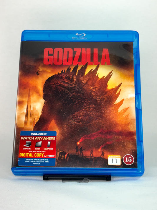 Forside av Blu-ray-cover til Godzilla – moderne monsterfilm med Bryan Cranston og Aaron Taylor-Johnson, brukt Blu-ray tilgjengelig hos Brukbar Film.