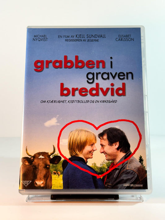 Forside av cover til grabben i graven bredvid, bruktfilm på DVD hos Brukbar Film