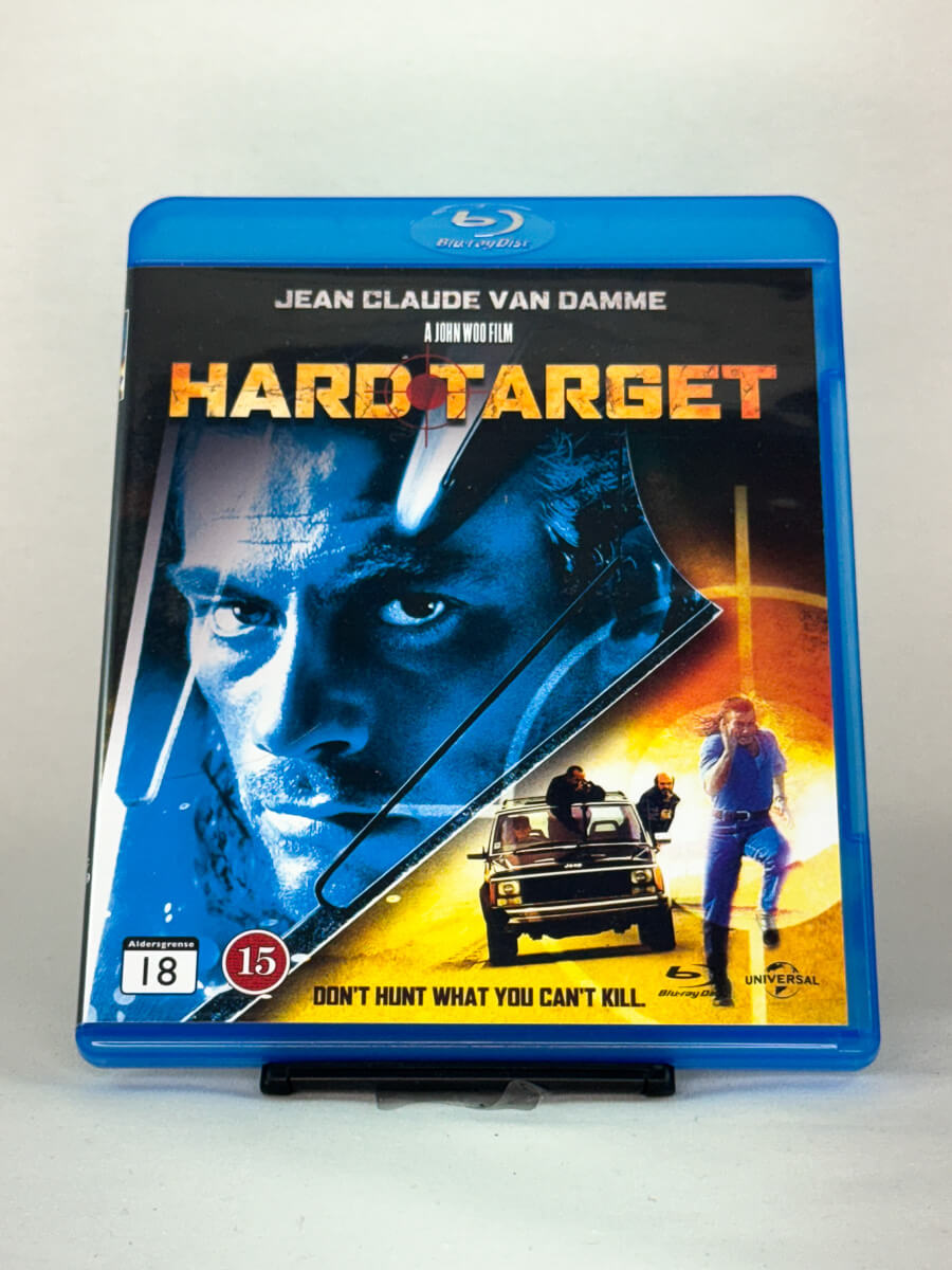 Forside av Blu-ray-cover til Hard Target – actionfilm med Jean-Claude Van Damme regissert av John Woo, fylt med eksplosjoner og høyoktan kamp, brukt Blu-ray hos Brukbar Film.