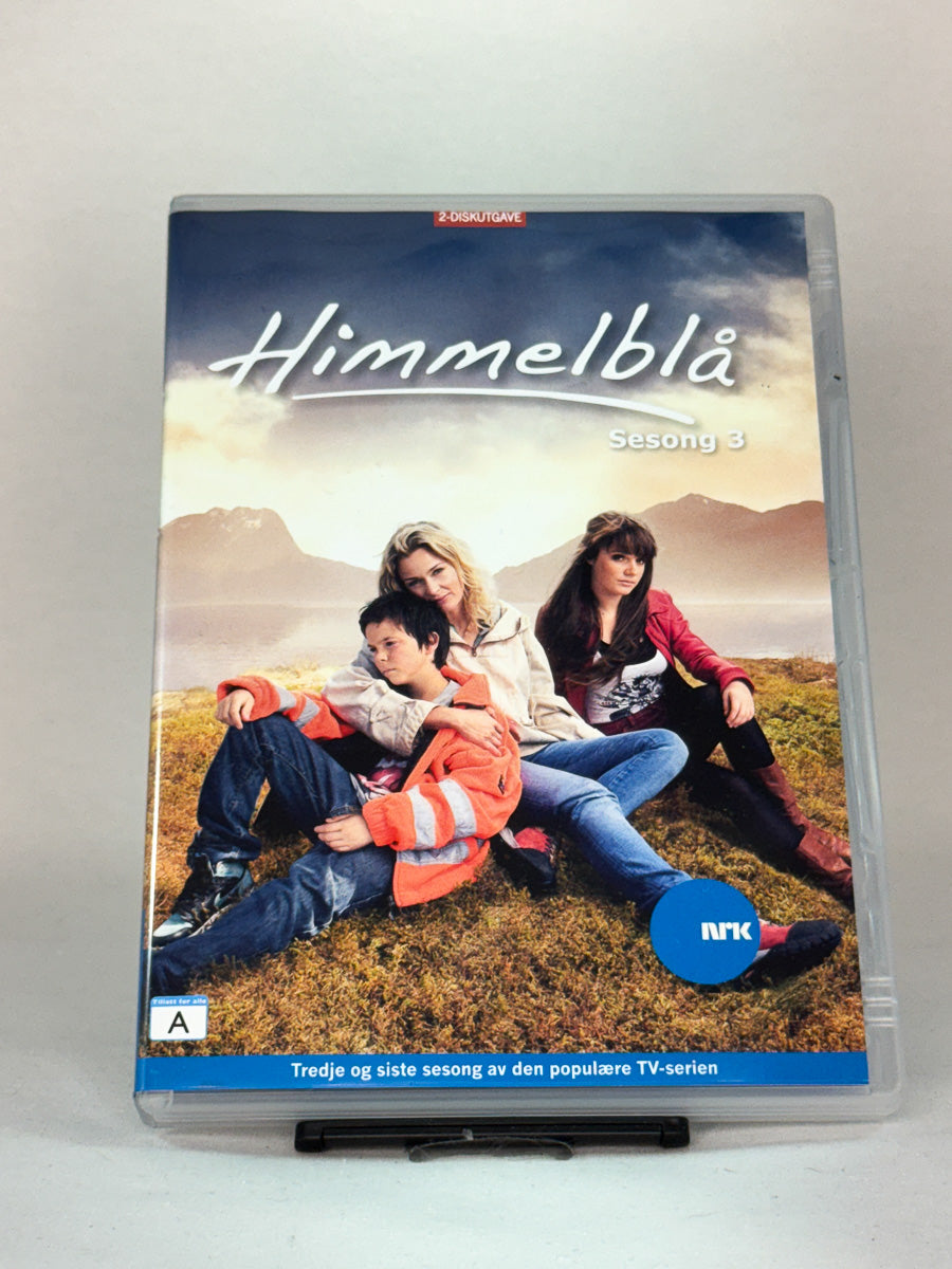 Forside av DVD-cover til «Himmelblå – Sesong 3» – siste sesong av den populære NRK-serien, utgitt på brukt DVD hos Brukbar Film.