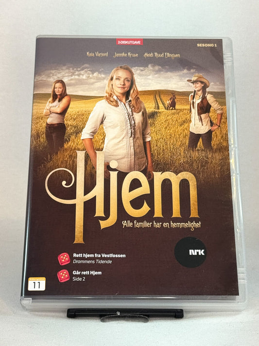 Forside av DVD-cover til Hjem – Sesong 1 – NRKs dramaserie om hemmeligheter, slektsbånd og livet i bygda, brukt norsk TV-serie på DVD hos Brukbar Film.