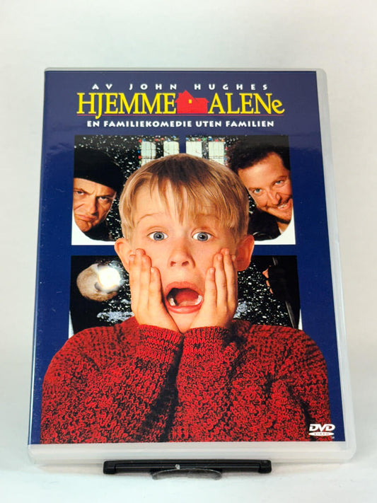 Forside av DVD-cover til Hjemme Alene (Home Alone) – klassisk julekomedie skrevet av John Hughes, med Macaulay Culkin i hovedrollen, brukt DVD hos Brukbar Film.