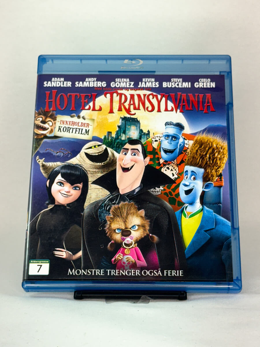 Forside av Blu-ray-cover til Hotel Transylvania – morsom animasjonsfilm der Dracula driver hotell for monstre, med stemmer av Adam Sandler og Selena Gomez, brukt Blu-ray hos Brukbar Film.