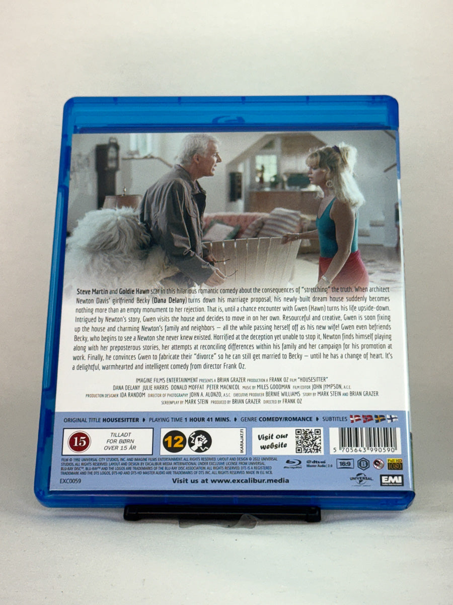 Bakside av Blu-ray-cover til Housesitter – humoristisk kjærlighetshistorie om løgner, forviklinger og et uventet samboerskap, brukt Blu-ray hos Brukbar Film.