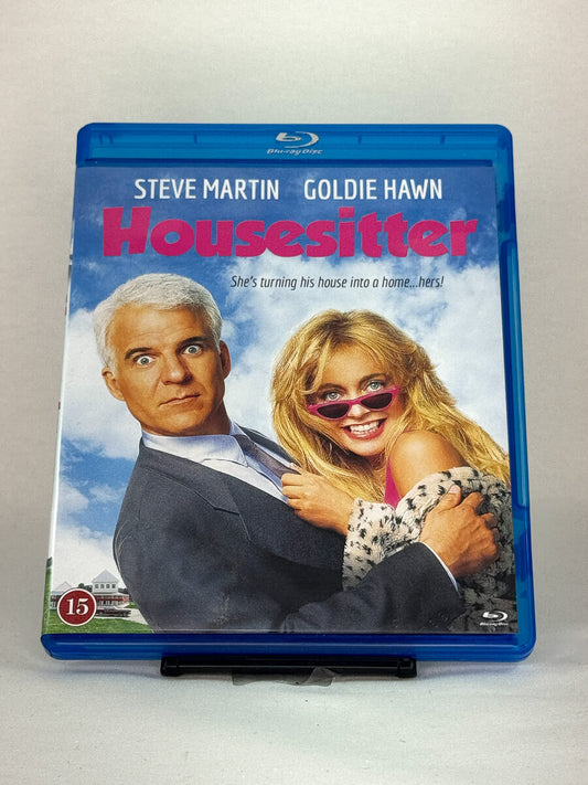Forside av Blu-ray-cover til Housesitter – romantisk komedie med Steve Martin og Goldie Hawn, full av forviklinger og sjarm, brukt Blu-ray hos Brukbar Film.