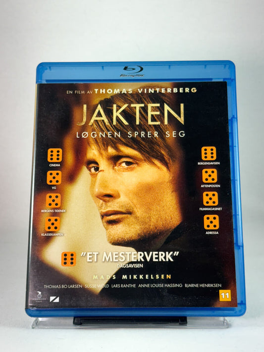 Forside av Blu-ray-cover til Jakten – dansk drama av Thomas Vinterberg med Mads Mikkelsen i hovedrollen, brukt film hos Brukbar Film.