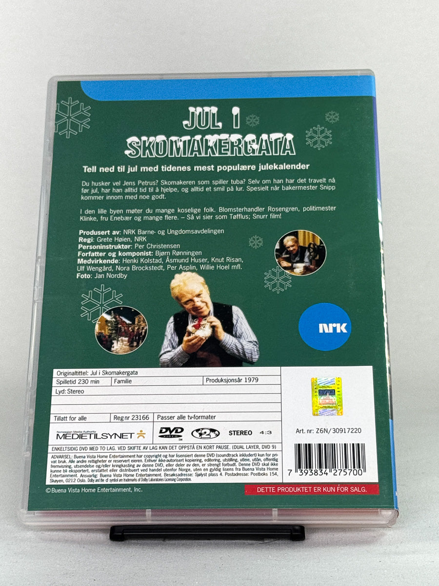 Bakside av DVD-cover til Jul i Skomakergata 2 – inneholder informasjon om episodene og NRKs klassiske juletradisjon – brukt DVD tilgjengelig hos Brukbar Film.