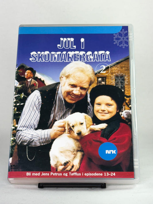 Forside av DVD-cover til Jul i Skomakergata 2 – fortsettelsen av den populære julekalenderen med Jens Petrus og Tøfflus i episodene 13–24 – brukt DVD hos Brukbar Film.