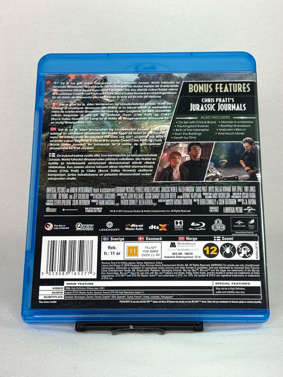 Bakside av Blu-ray-cover til Jurassic World: Fallen Kingdom – eksplosiv oppfølger i den ikoniske Jurassic-serien, Blu-ray hos Brukbar Film.