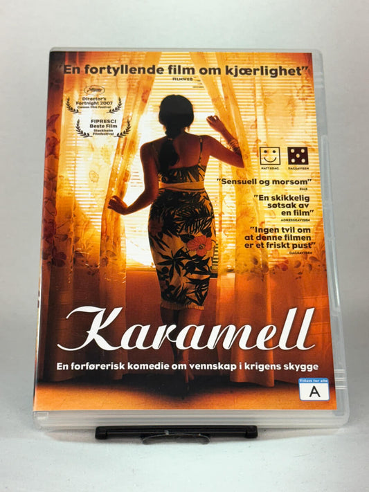 Forside av DVD-cover til filmen Karamell (originaltittel: Caramel / Sukkar Banat) – en prisbelønt komedie fra Beirut, brukt DVD tilgjengelig hos Brukbar Film