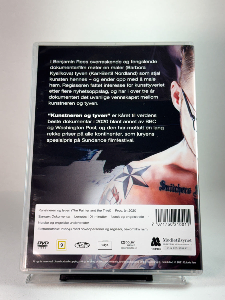 Bakside av DVD-cover til Kunstneren og tyven med festivalpriser og produksjonsinfo; brukt dokumentar-DVD hos Brukbar Film