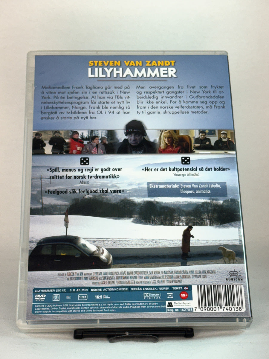 Bakside av DVD-cover til Lilyhammer – Sesong 1 – hele første sesong med 8 episoder av NRKs suksesserie om kulturkrasj, kriminalitet og humor, brukt originalserie på DVD hos Brukbar Film.