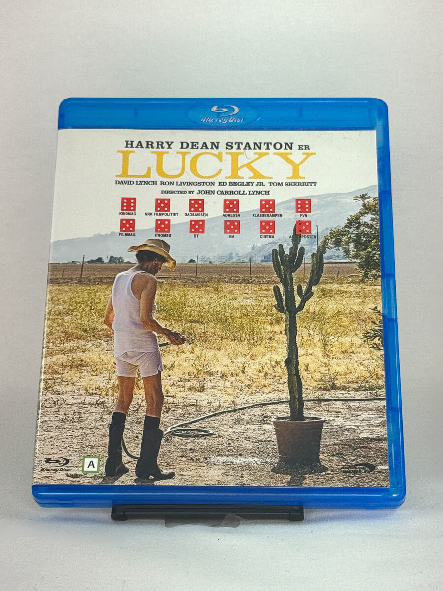 Forside av Blu-ray-cover til Lucky med Harry Dean Stanton i hovedrollen – stillferdig amerikansk drama om livets siste reise, brukt Blu-ray hos Brukbar Film.