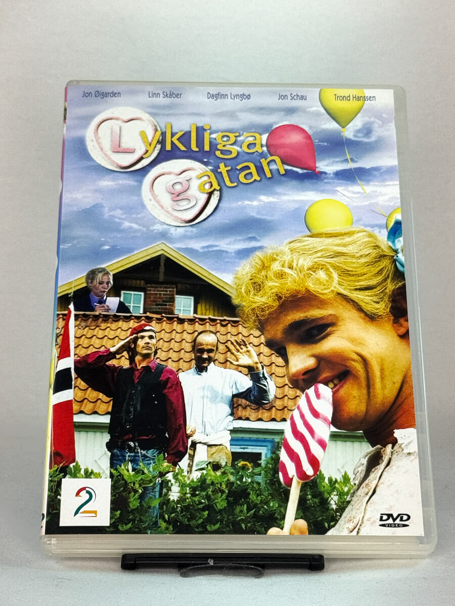 Forside av DVD-cover til Lyckliga gatan – norsk komiserie med Jon Øigarden, Linn Skåber, Dagfinn Lyngbø og Jon Schau, brukt DVD hos Brukbar Film.