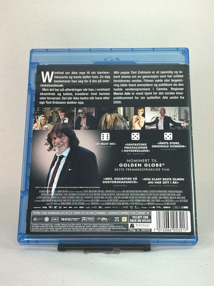 Bakside av Blu-ray-cover til Min pappa Toni Erdmann – kritikerrost og rørende europeisk drama regissert av Maren Ade, brukt Blu-ray hos Brukbar Film.