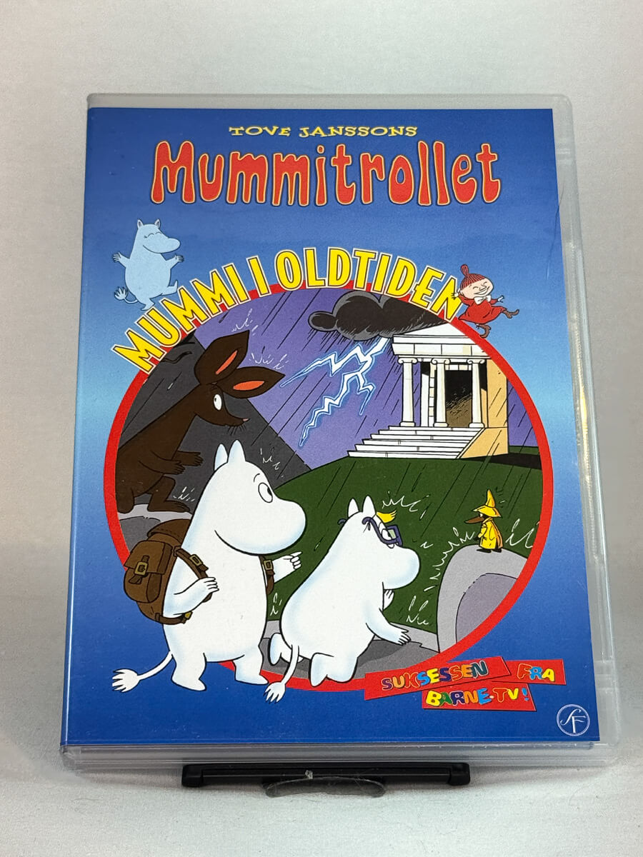 Forside av DVD-cover til Mummitrollet – Mummi i oldtiden – klassisk barnefilm basert på Tove Janssons fortellinger om Mummidalen og dens magiske eventyr, brukt familiefilm på DVD hos Brukbar Film.