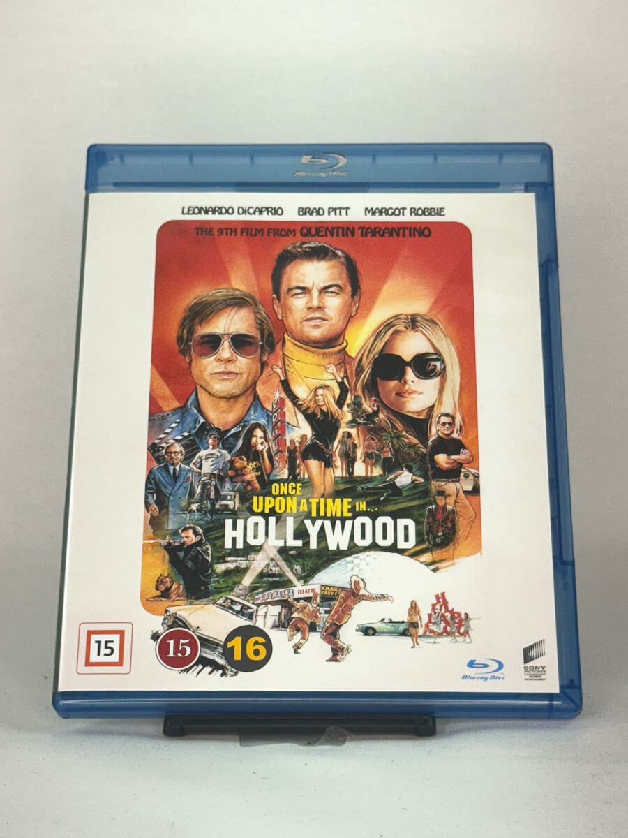 Forside av Blu-ray-cover til Once Upon a Time in Hollywood med Leonardo DiCaprio, Brad Pitt og Margot Robbie – Quentin Tarantinos nostalgiske 60-tallsdrama, brukt Blu-ray hos Brukbar Film.