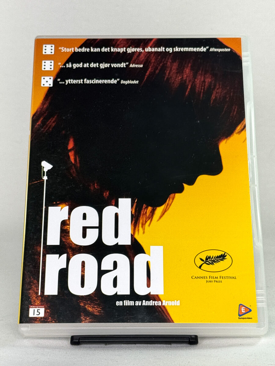 Forside av DVD-cover til Red Road – prisvinnende britisk drama av Andrea Arnold, kjent fra Cannes Film Festival, tilgjengelig som brukt DVD hos Brukbar Film.