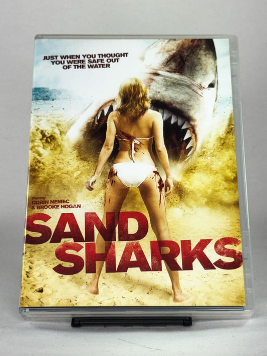Forside av DVD-cover til filmen Sand Sharks – galskap og haikaos på stranden i denne sprø monsterkomedien, bruktfilm hos Brukbar Film.