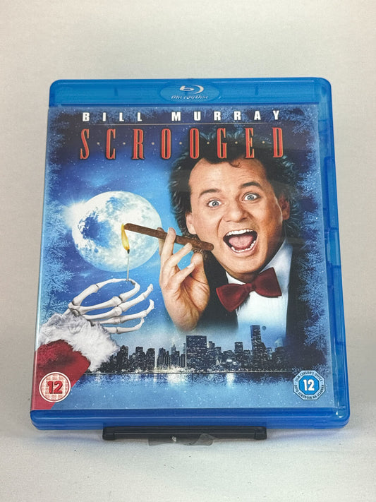 Forside av Blu-ray-cover for Scrooged – Bill Murray i moderne julekomedie basert på Dickens’ klassiker, brukt Blu-ray hos Brukbar Film.