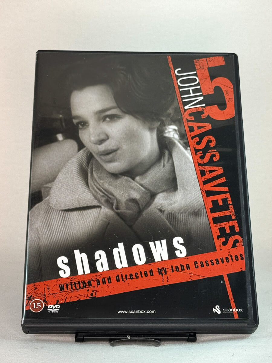 Forside av DVD-cover til Shadows (1959) – regissert av John Cassavetes, et banebrytende amerikansk drama kjent for sin improviserte stil og rå realisme – brukt film på DVD hos Brukbar Film.