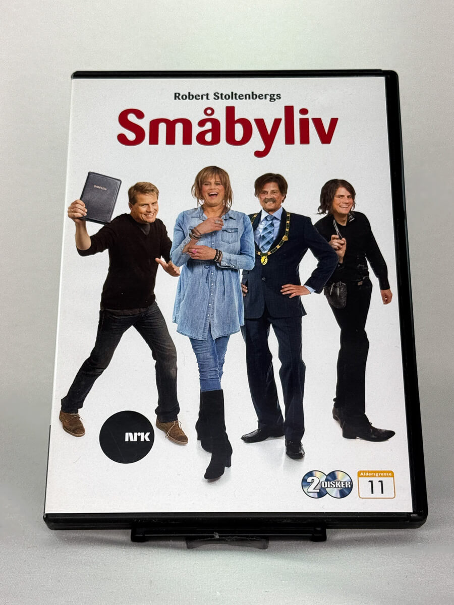 Forside av DVD-cover til Småbyliv – norsk komiserie med Robert Stoltenberg, original bruktfilm på DVD hos Brukbar Film