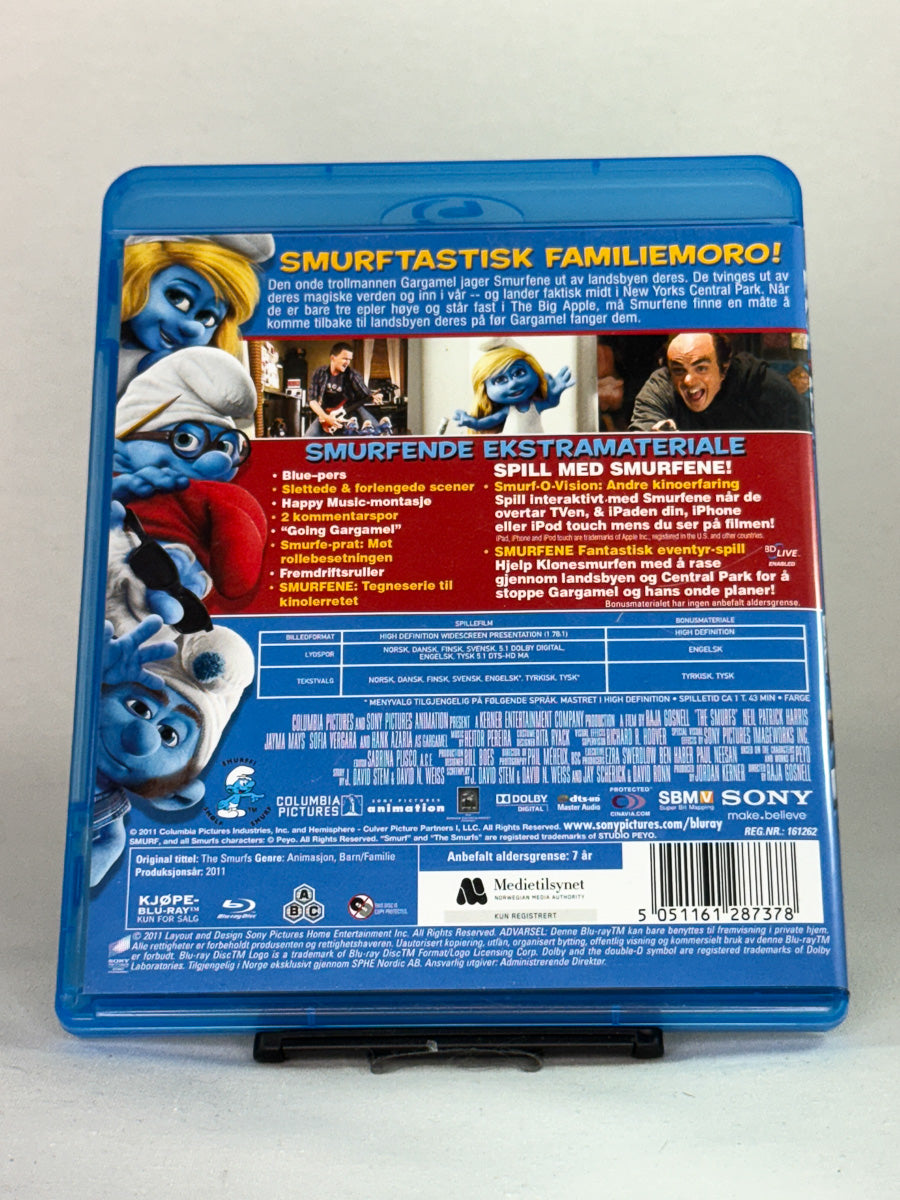 Bakside av Blu-ray-cover til Smurfene – animert eventyr basert på Peyos klassiske tegneseriefigurer, brukt Blu-ray-utgave for hele familien hos Brukbar Film.