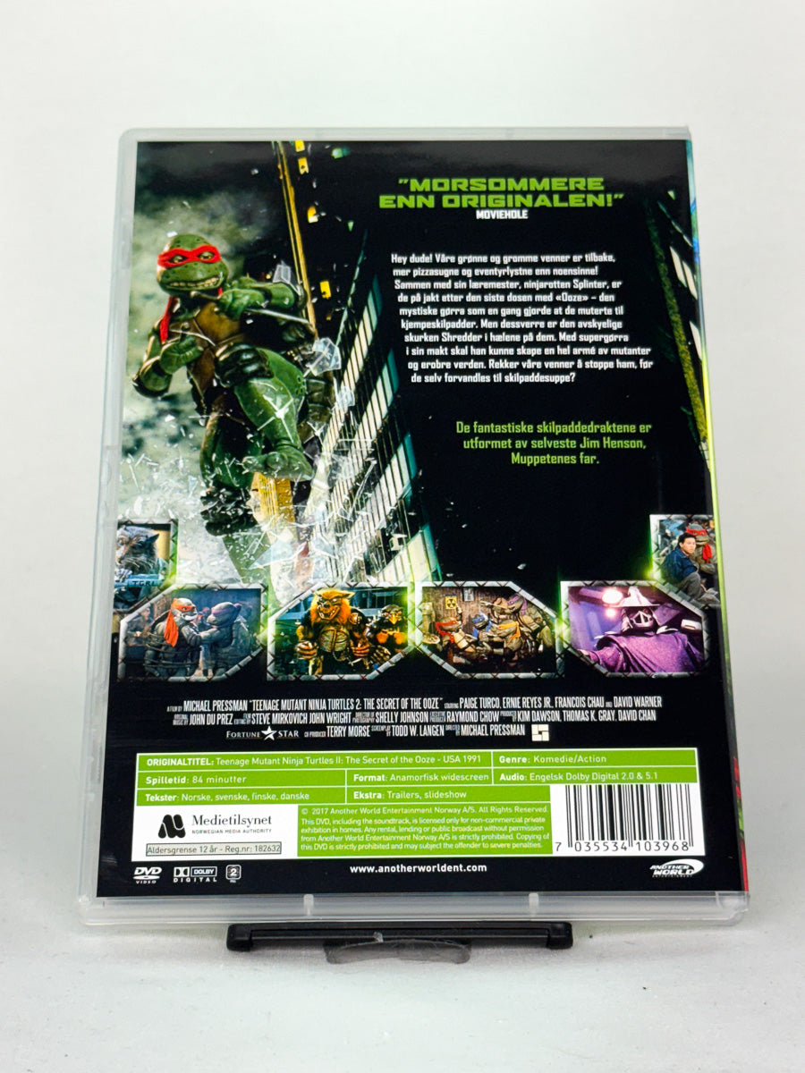 Bakside av DVD-cover til Teenage Mutant Ninja Turtles 2: Kampen om den grønne gjørra – brukt DVD med barne- og familievennlig actioneventyr, tilgjengelig hos Brukbar Film