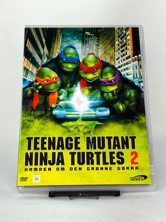 Forside av DVD-cover til Teenage Mutant Ninja Turtles 2: Kampen om den grønne gjørra – brukt DVD med kultklassiker fra 90-tallet, kjøp hos Brukbar Film