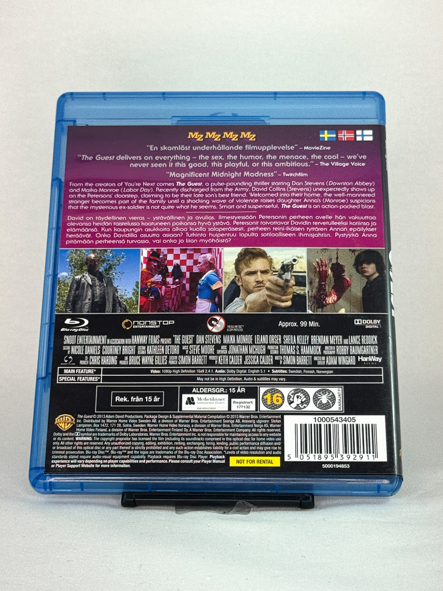 Bakside av Blu-ray-cover til The Guest – stilfull actionthriller med Maika Monroe, brukt Blu-ray-utgave hos Brukbar Film.