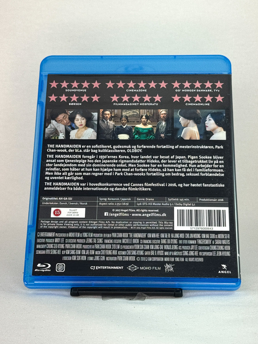 Bakside av Blu-ray-cover til The Handmaiden – kritikerrost sørkoreansk mesterverk fylt med bedrag, lidenskap og visuell perfeksjon, brukt Blu-ray-utgave hos Brukbar Film.