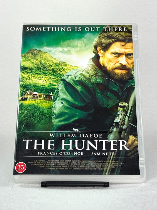 Forside av DVD-cover til The Hunter – australsk thriller med Willem Dafoe og Sam Neill, basert på romanen av Julia Leigh, tilgjengelig hos Brukbar Film.