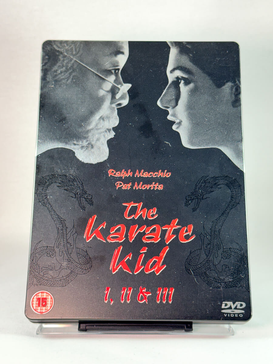 Forside av DVD-cover til The Karate Kid 1, II & III, klassisk kampsportserie i samleboks, brukt DVD hos Brukbar Film