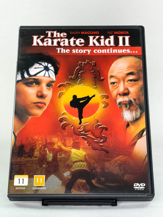 Forside av DVD-cover til The Karate Kid II – actiondrama med Ralph Macchio og Pat Morita, brukt DVD hos Brukbar Film